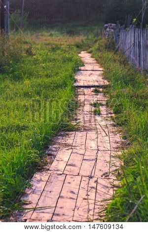 Track from boards illuminated by the sun at sunset
