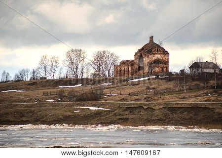 Ice drift on the river a little North of Russia. On the background of the old ruined Church in the village.