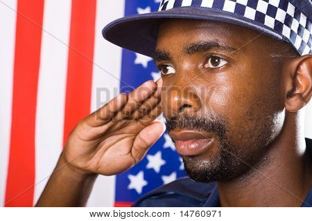 Africký Americký policista zdravení, pozadí je vlajka USA