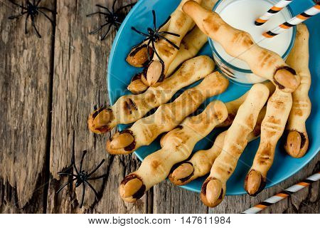 Halloween witch's fingers cookies on a plate on the old wooden background top view blank space for text
