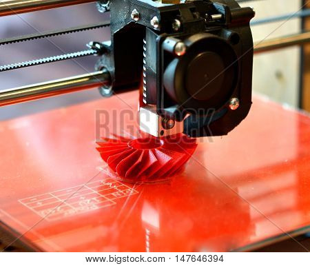 3D printer prints red shapes on a red background