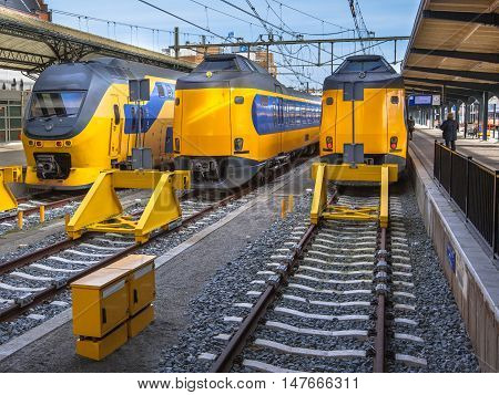 Three Fast Modern Passenger Commuter Transport Trains Waiting At A Station