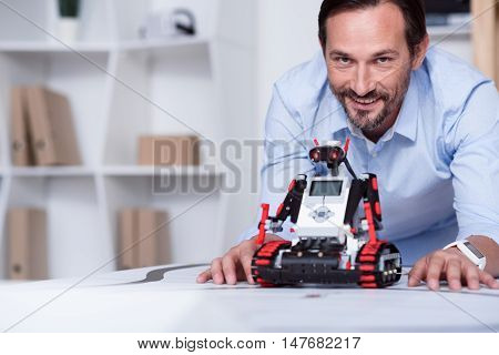 Well done. Energetic good-looking man presenting a robot he created