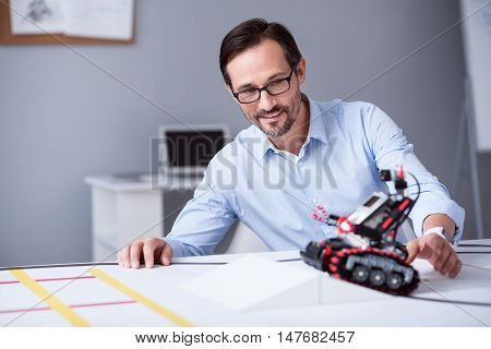 Happieness of creation. Inventor checking out the work of his new electronic device.