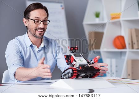 Everything works Middle-aged white male turning a machine on while performing an experiment