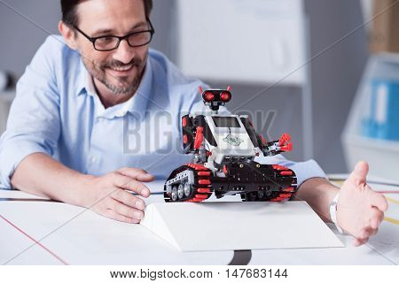Happy. Satisfied creator checking out a robot overcoming obstacles in the lab