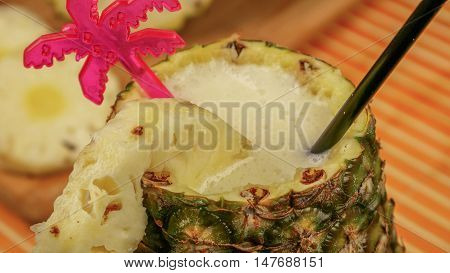 Pina colada - alkohol drink with straw inside pineapple