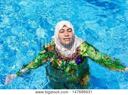 Muslim Arabic woman with burkini in pool