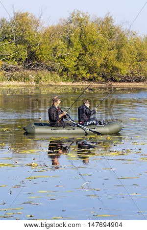 The river Chaus Kolyvan district Novosibirsk oblast, Siberia, Russia - September 17, 2016: fishermen in an inflatable rowing boat with a spinning rod looking for a predatory fish on the river.