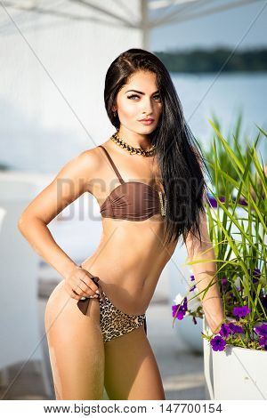 Fashion shoots girlfriend on the white sand in the swimsuit with glasses