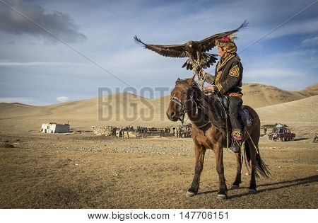 Bayan Ulgii Mongolia September 30th 2015: Mongolian eagle hunter with his eagle and horse