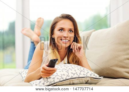 Picture of young woman on couch watching tv