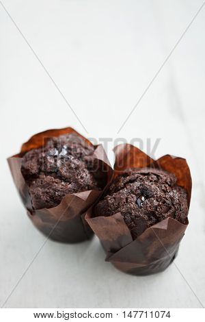 Two Tasty Chocolate Muffins On Wooden Table