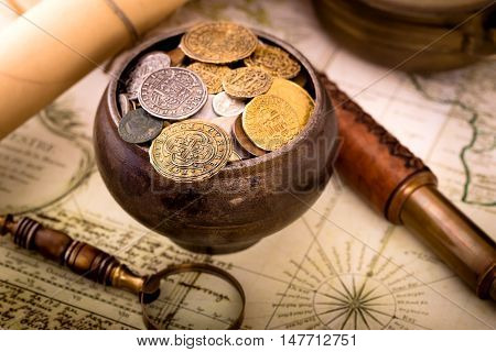 Treasure pot with coins on old map background