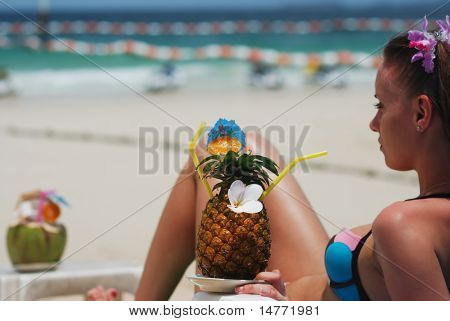 Meisje met tropische cocktail op het strand