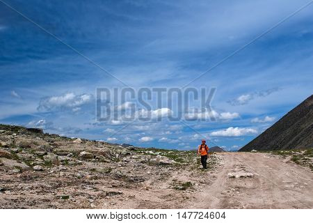 ALTAY, RUSSIA - JULY 23, 2007: Hiker walking on the road to Ukok plateau in the Altay Mountains Russia