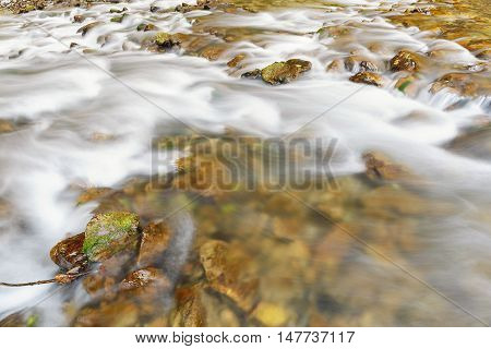 River flowing through rocks, close up. Water texture background