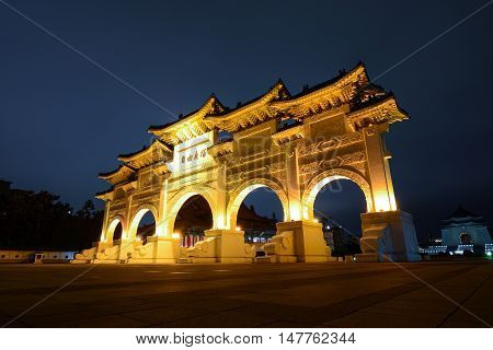 TAIPEI, TAIWAN - SEPTEMBER 8, 2016 - Liberty Square Gate of Integrity at night in front of Chiang Kai-shek Memorial Hall in Taipei, Taiwan. The Chinese text says: 