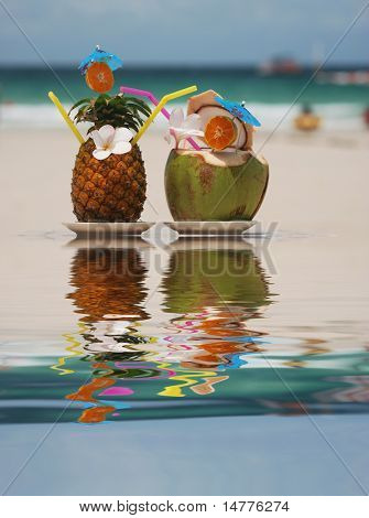Tropische cocktails op het strand. Weerspiegeling in water.