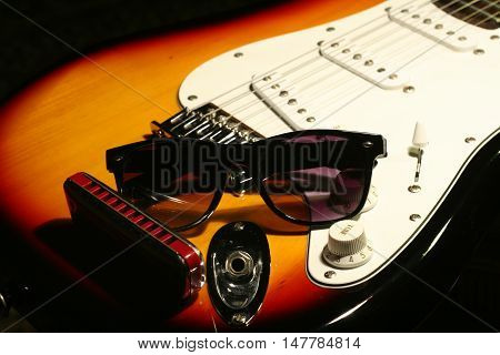 Vintage Electric Guitar, Harmonica, Sunglasses On Black Background