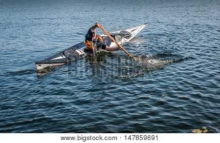 man rolling with a kayak on a lake - serial pictures 10 of 11