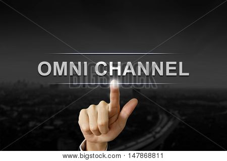 business hand clicking omni channel button on black blurred background