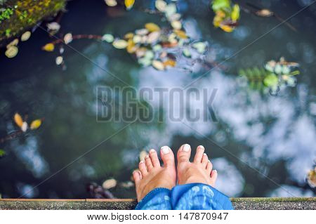 Relaxing foot bath in a pond with fish to swim . The luxurious Grand shady garden