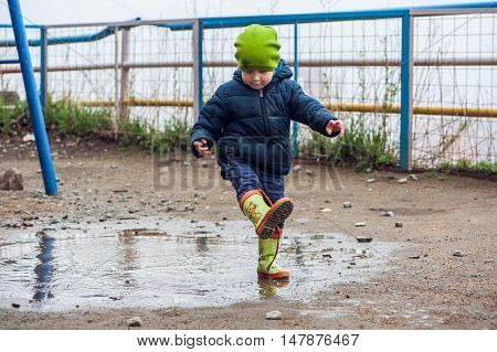 Toddler Boy Jumping In The Puddles