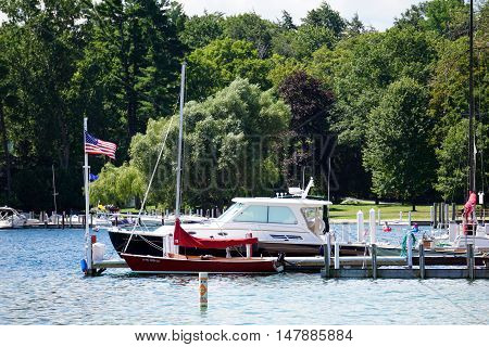 HARBOR SPRINGS, MICHIGAN / UNITED STATES - AUGUST 1, 2016: Boats are docked at a private pier next to the Zorn Park Public Beach in Harbor Springs.