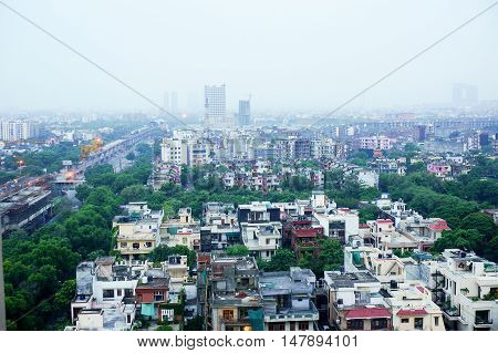 View of noida city at dawn from a skyscraper. Shows the many homes, apartments, traffic and newly constructed metro