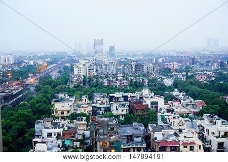 View of noida city at dawn from a skyscraper. Shows the many homes, apartments, traffic and newly constructed metro