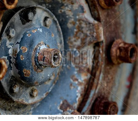 picture of a details close upof and old rusty truck wheel