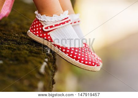 Close up of red polka dot shoes on child's feet