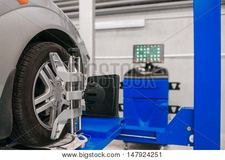 Car on stand with sensors on wheels for wheels alignment camber check in workshop of Service station.