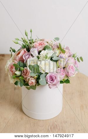 Rich bunch of composition in hatbox. A fresh bouquet of flowers of different colors mix.