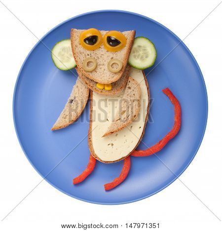 Funny monkey made of bread cheese and vegetables on plate