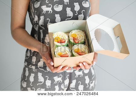 A Bunch Of Cakes Are In The Hands Of A Woman. Strawberries, Kumquat And Whipped Cream. Craft Packagi