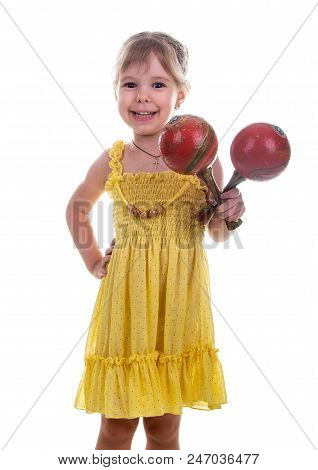 Little Girl In A Bright Yellow Dress Holding Maracas In Her Hands. Studio Photo, Bright White Backgr