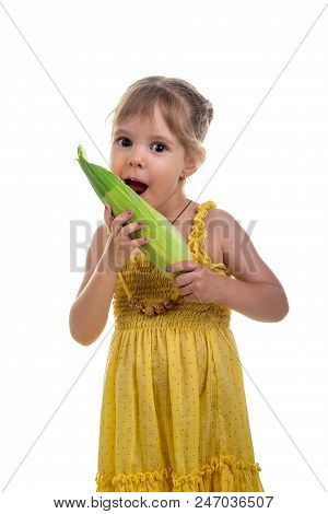 Little Girl In A Bright Yellow Dress With Ear Of Corn. Studio Photo, Bright White Background.