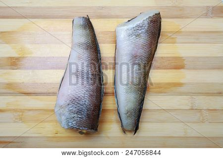 Two Pieces Of Fish Notothenia On A Cutting Board Close-up