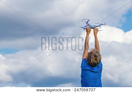 Child Playing With Drone Outdoors Against Blue Sky