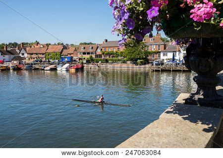 Skyline Of Henley On Thames In Oxfordshire Uk With Rower On River Thames In Foreground