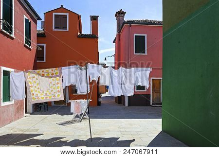 Europe,italy,venetia, The Laundry Spread Out To Dry Between The Typical Colorful Houses Of Burano Is