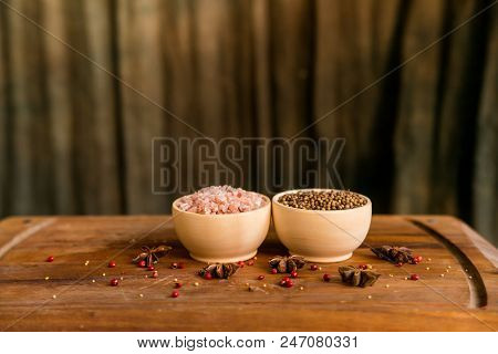 Pink Himalayan Salt And Coriander Seeds In White Bowls On Wooden Surface Covered With Anise And Red 