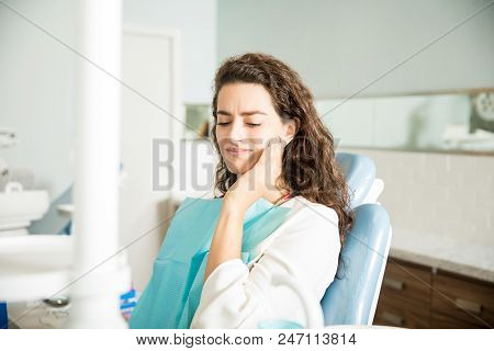 Young Woman Suffering From Toothache In Dental Clinic