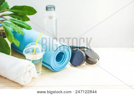 Set For Sports. Yoga Mat Towel Headphones And A Bottle Of Water On A Light Background The Concept Of
