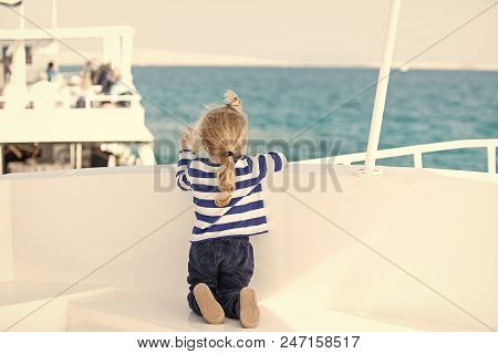 Yachting And Sailing. Small Cute Child Sitting Back On White Yacht. Childhood And Baby Care Concept.