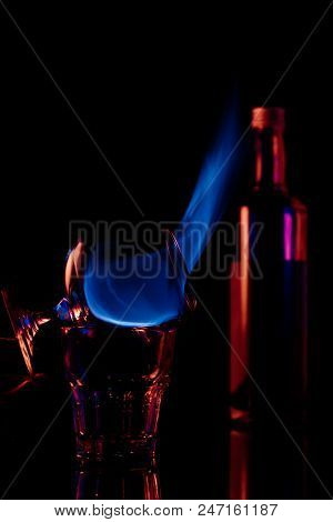 Close Up View Of Alcohol Sambuca Drink Burning In Glass On Black Background