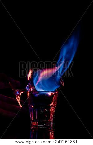 Partial View Of Woman Holding Glass With Burning Sambuca Alcohol Drink On Black Background