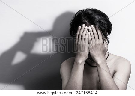 Man With Depression Sitting Head In Hands With Shadow Of Gun That Was Pointing His Head, Thinking To